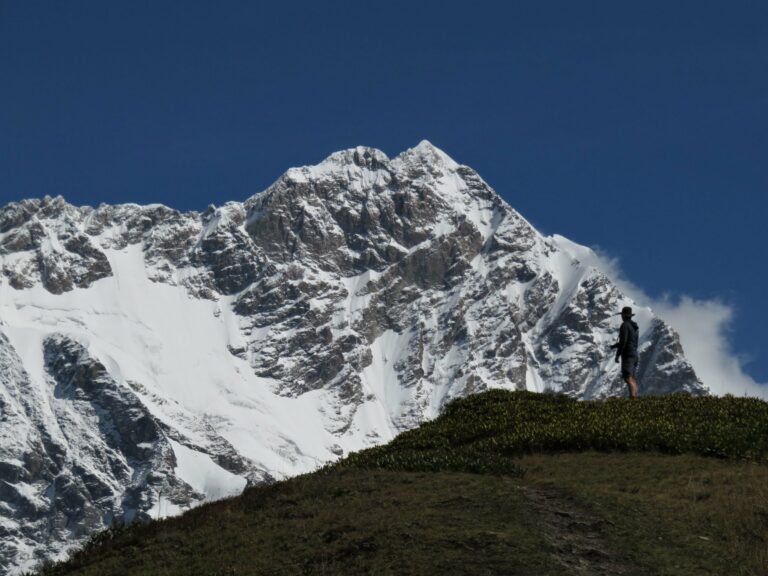 A hiker below the snowy peaks of the Caucasus