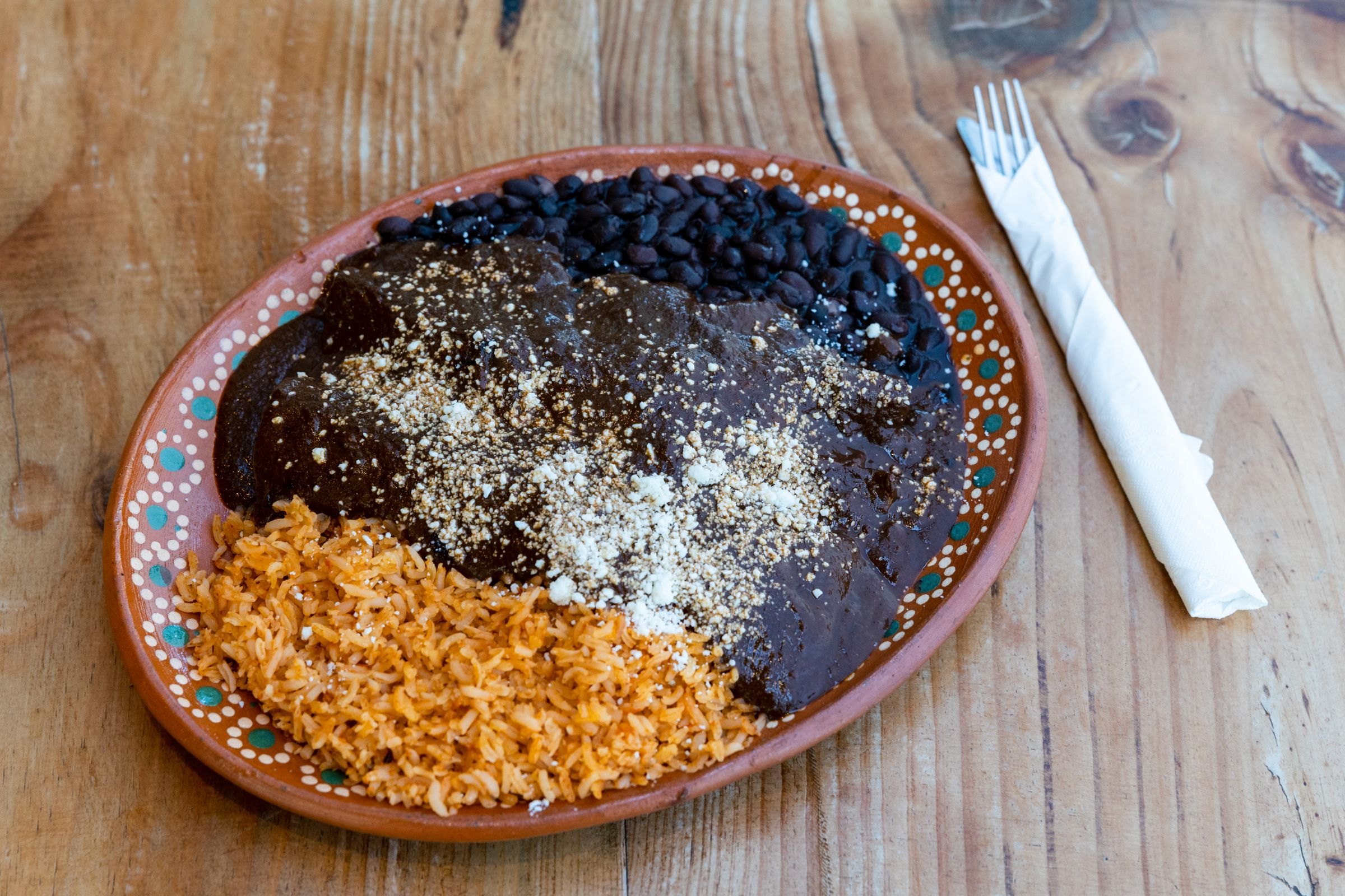 A plate of mole with rice and beans