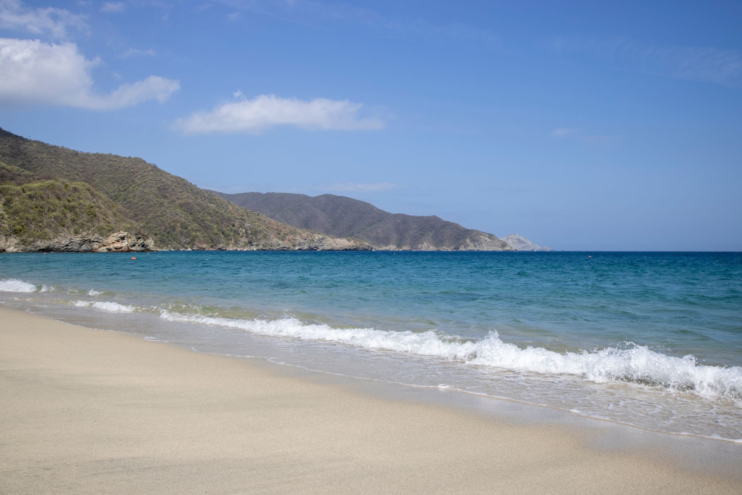 A sandy beach and mountains in Tayrona