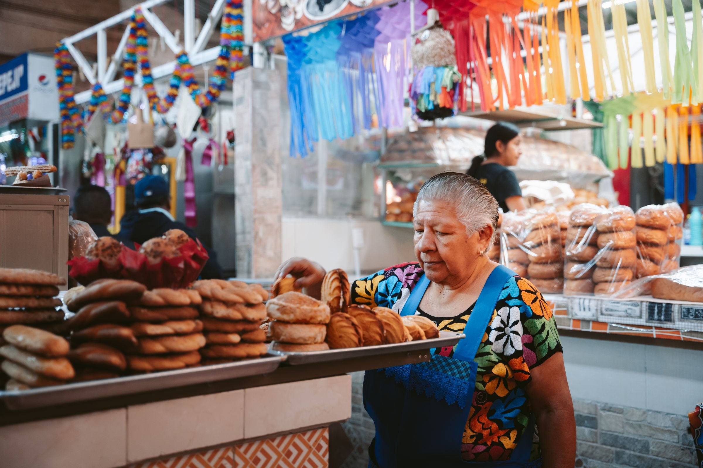 A woman at a bakery stall in an Oaxaca market