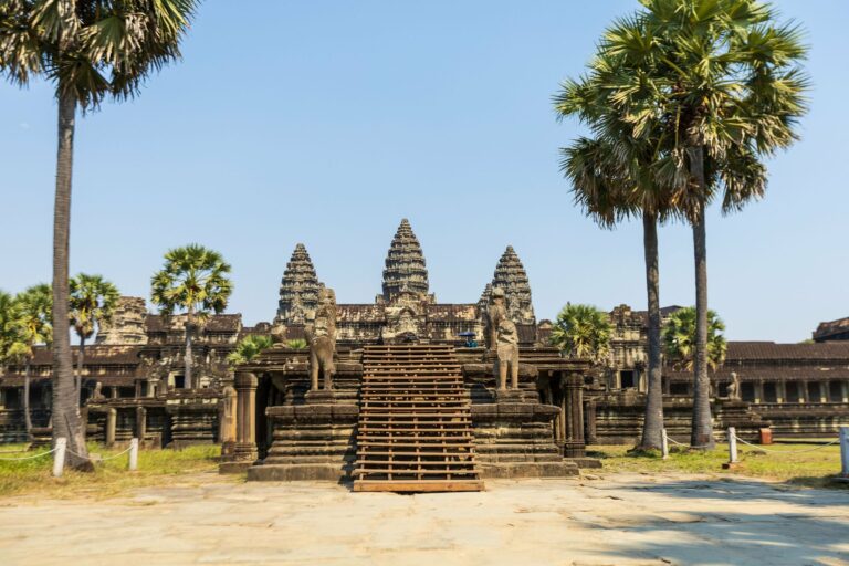The entrance to Angkor Wat among palm trees