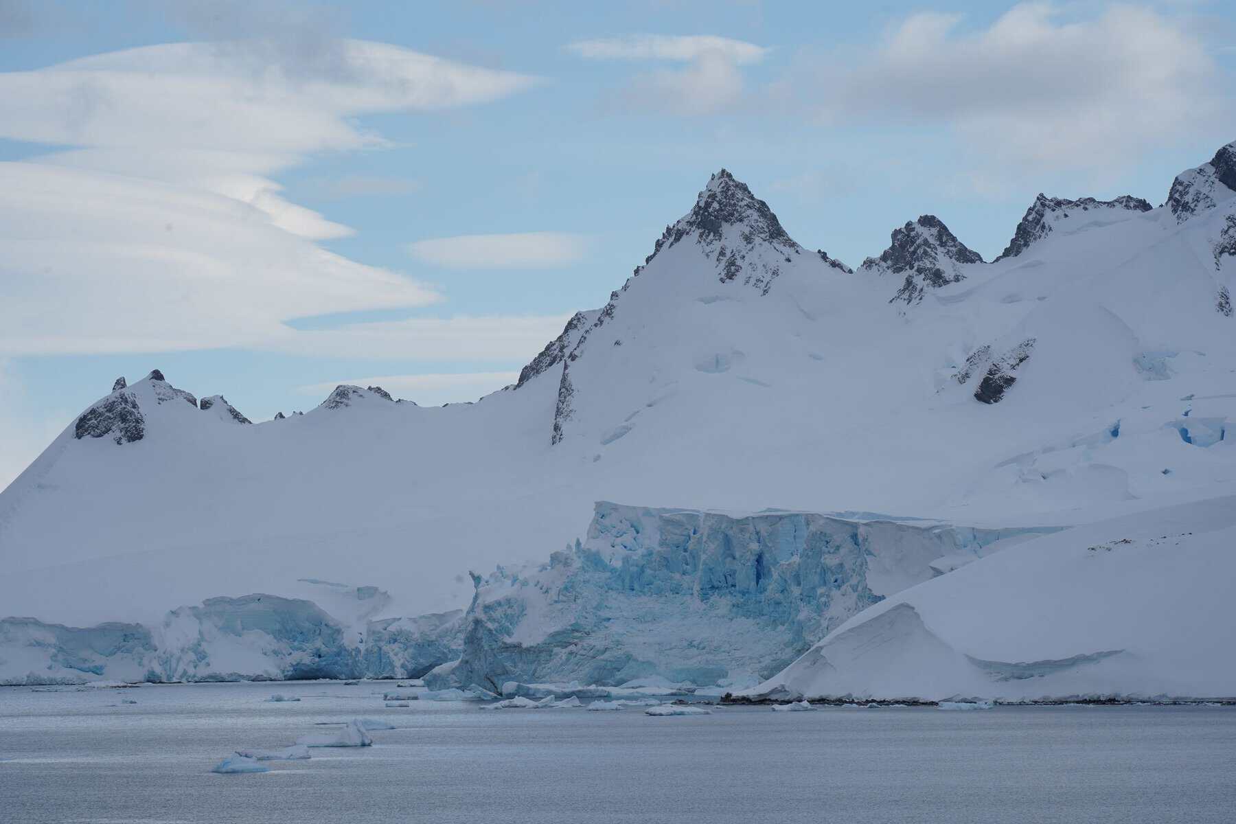 An Antarctic glacier beneath rugged peaks