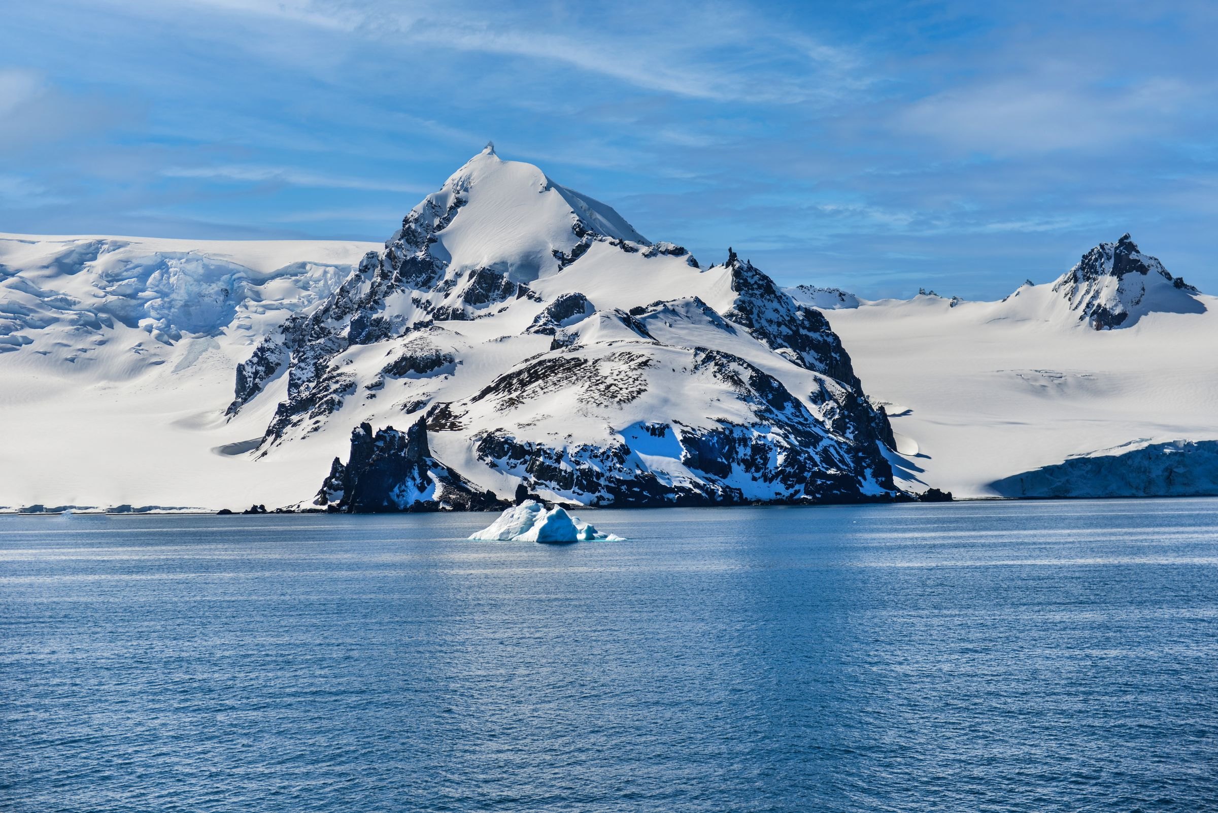 A snow-covered mountain and iceberg in Antarctica