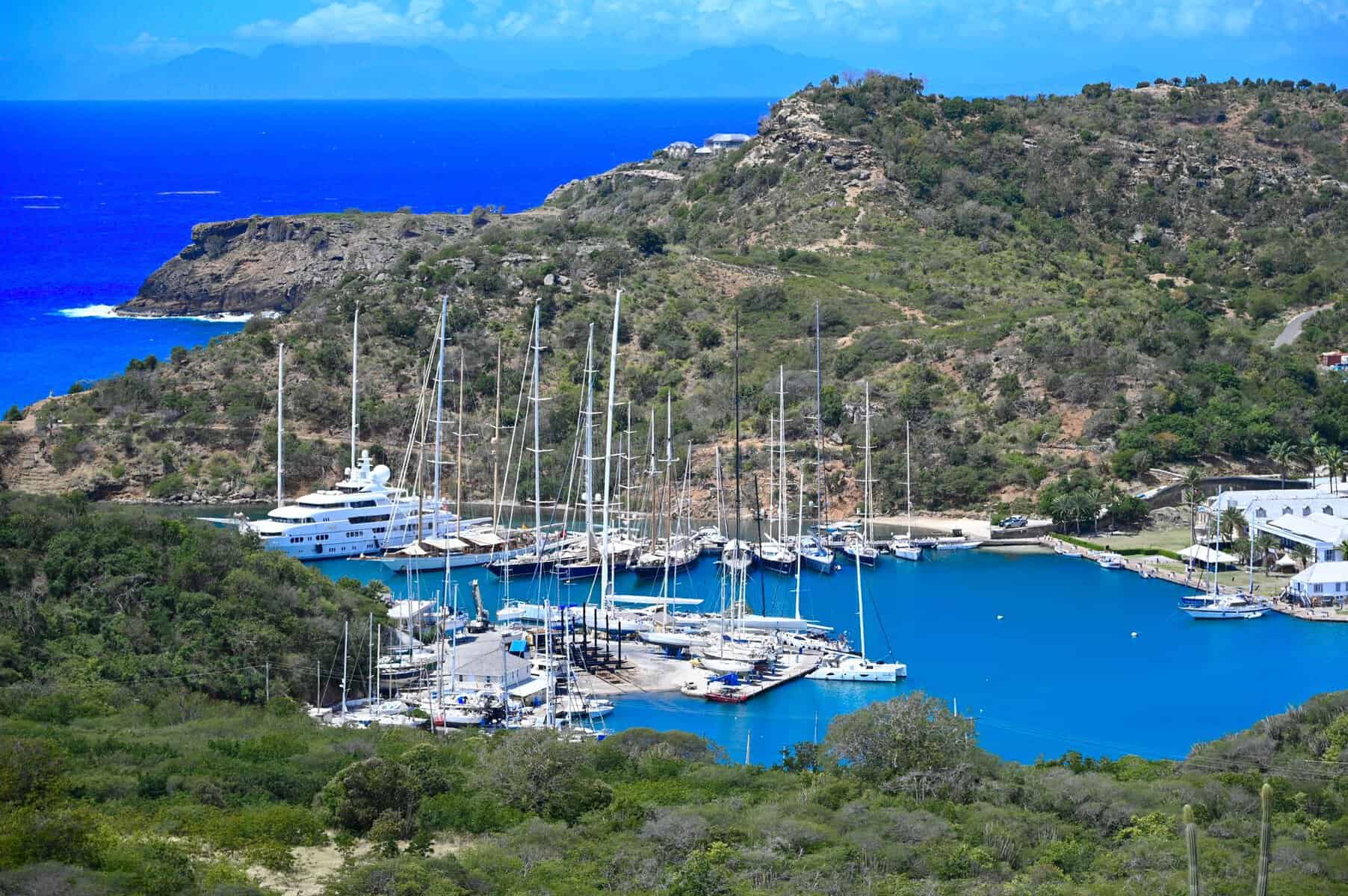 Aerial view of a sheltered harbour with yachts and green hills in Antigua