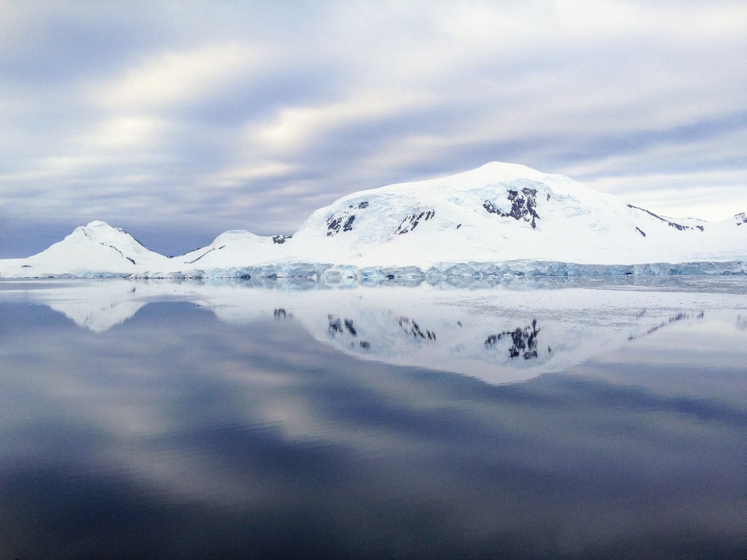 Snowy mountains reflected in Arctic waters