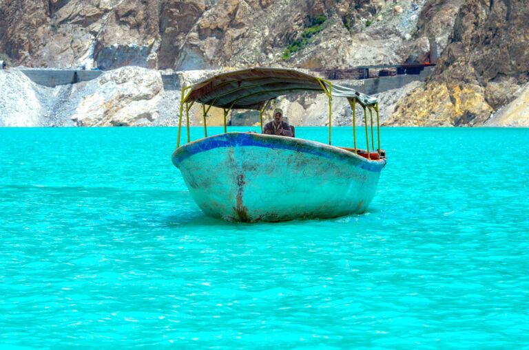 A boat on the turquoise water of Attabad Lake