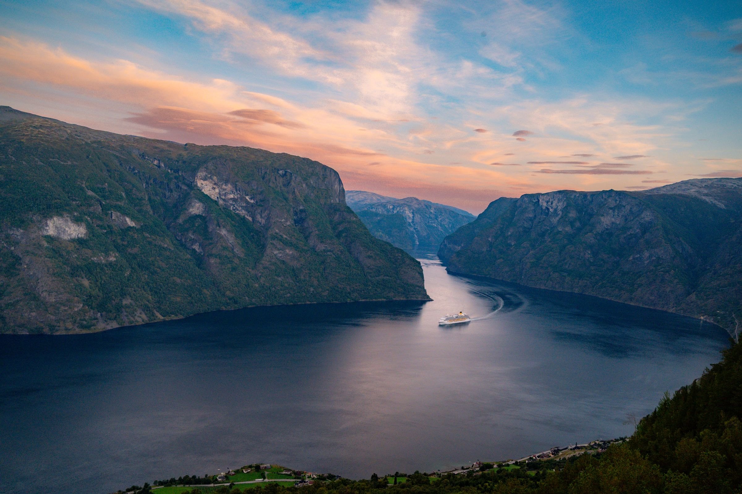 A cruise ship in a Norwegian fjord at sunset