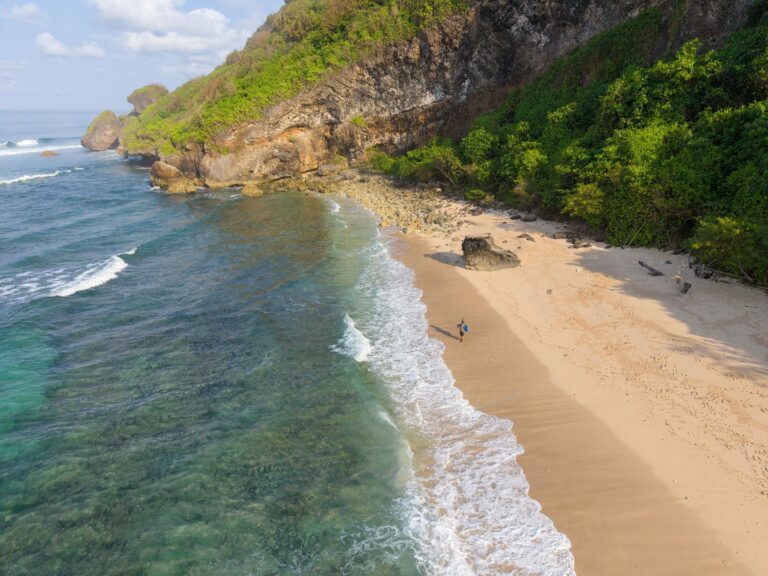 A beach below green cliffs in Bali