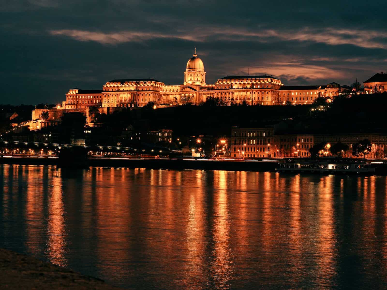 Buda Castle lit up at night above the Danube, Budapest
