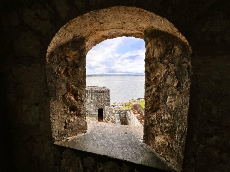 A view through a stone window of the Castillo de San Felipe on the Río Dulce