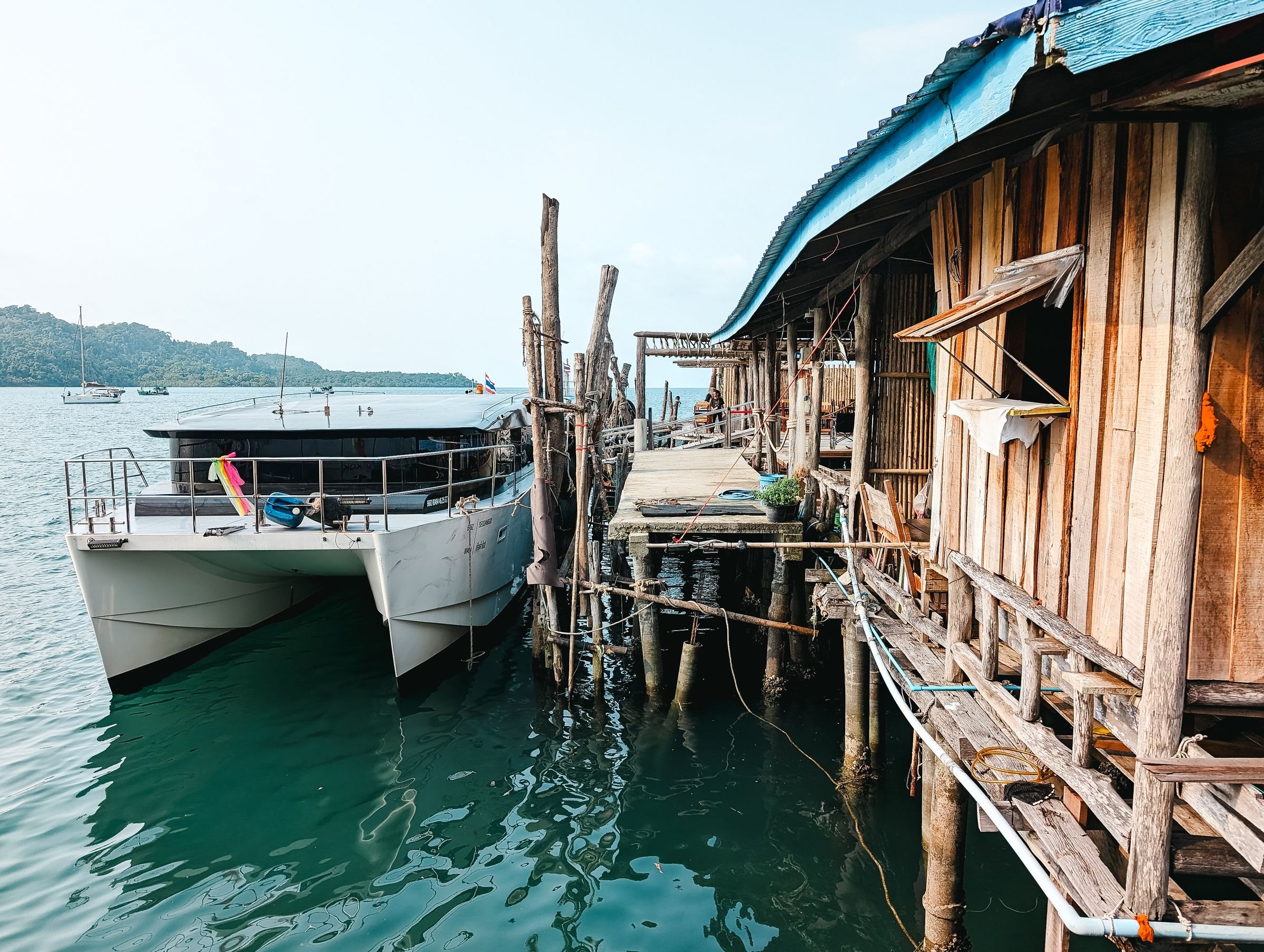 A catamaran moored beside a wooden pier