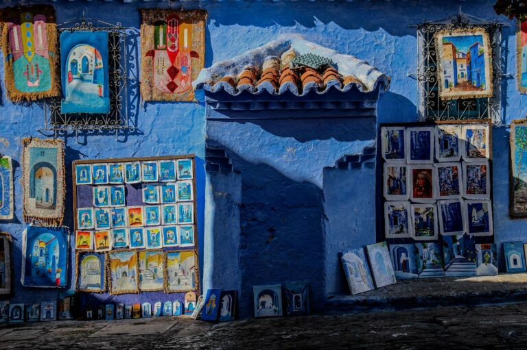 Colourful artwork on a blue wall in Chefchaouen