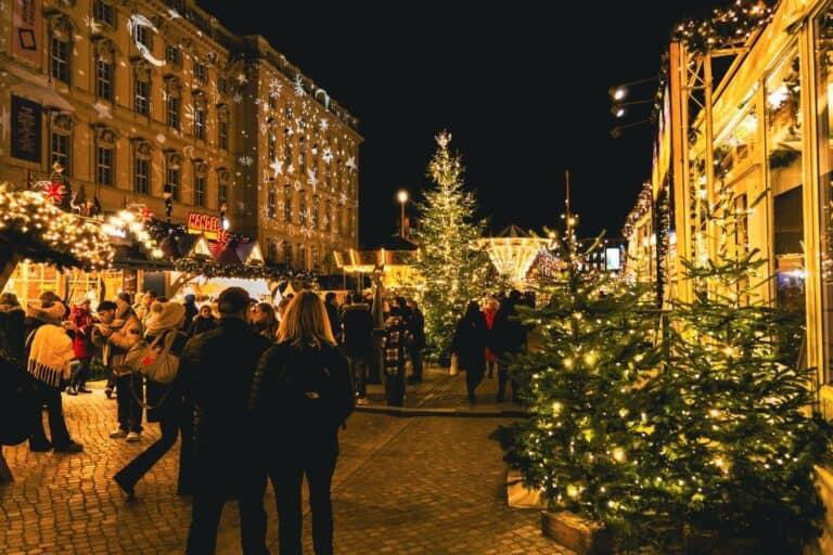 A Christmas market at night with lit stalls and trees