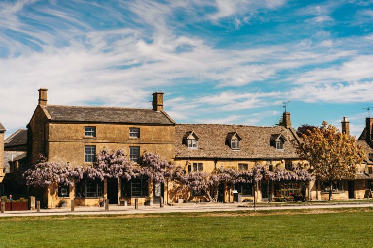 A historic Cotswold house covered in wisteria