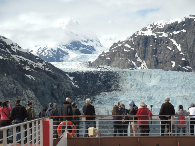 Passengers watching a glacier from a cruise deck