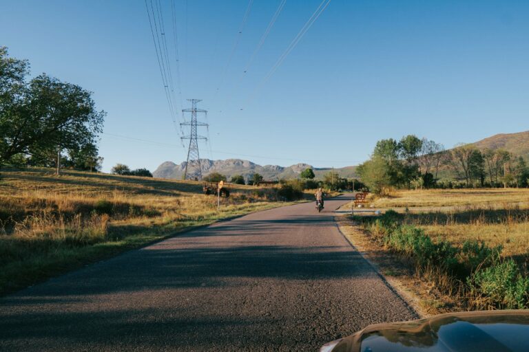 A cyclist on a country road in Albania at golden hour