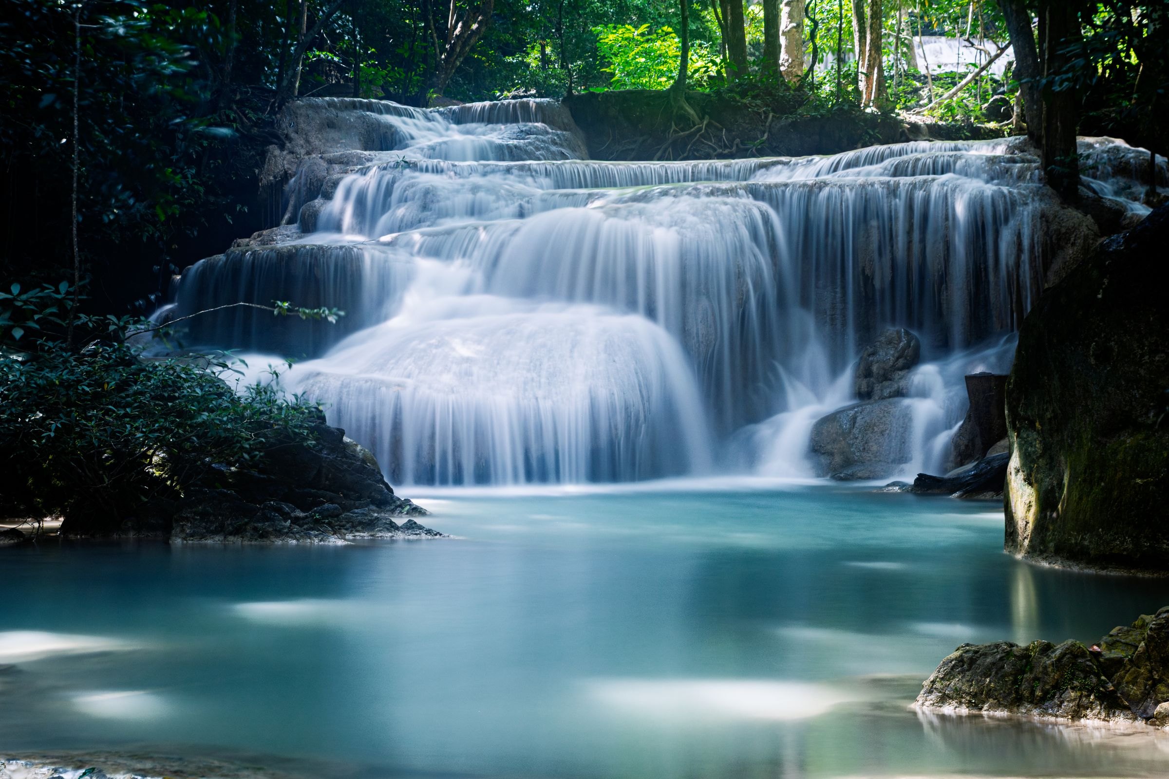 A waterfall cascading through the forest at Erawan