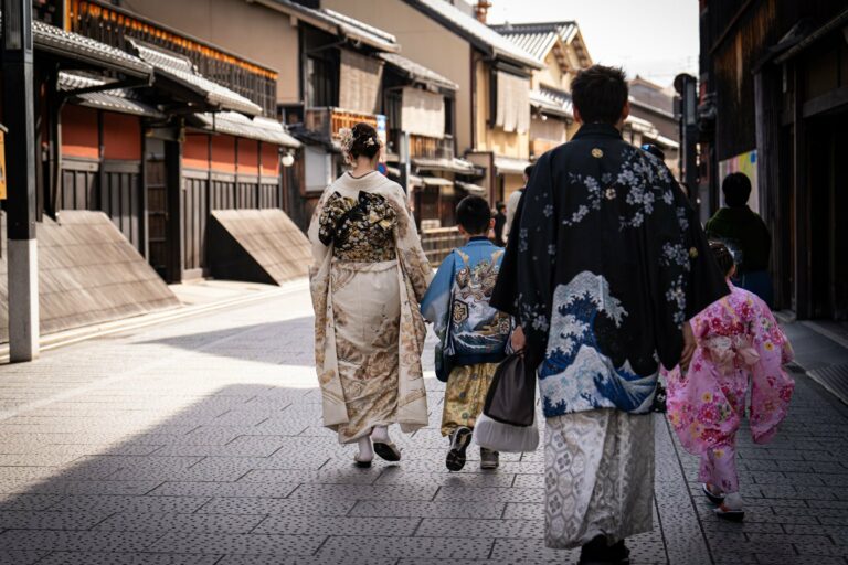 A family in kimonos walking through a historic street in Kyoto
