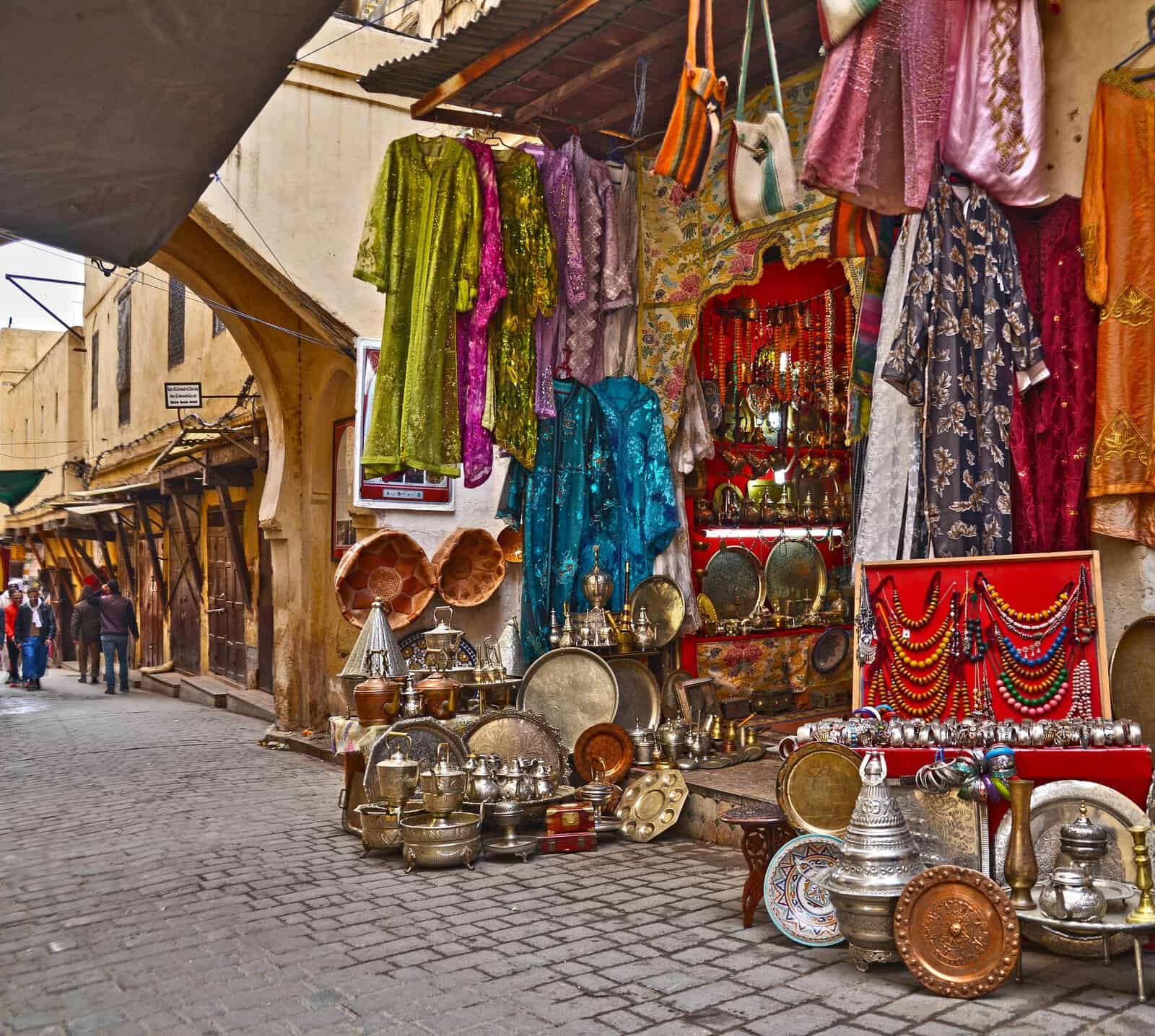 Fabrics and metalwork at a souk stall in the medina of Fes, Morocco