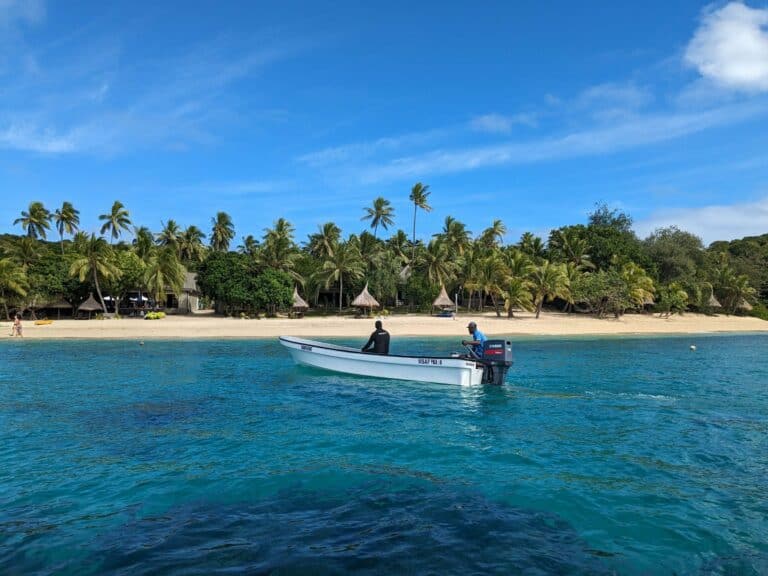 A boat off a palm-covered island in Fiji