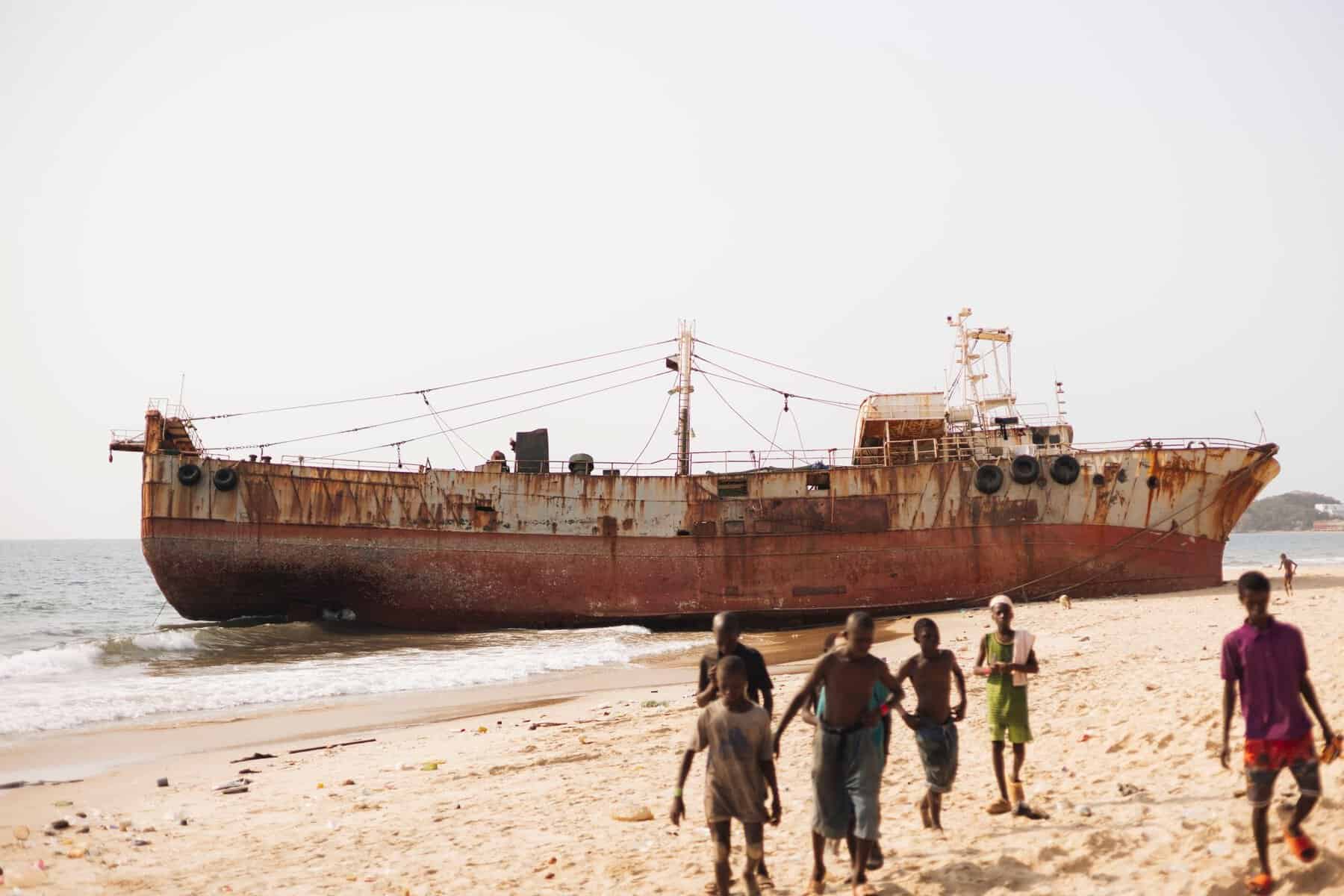 A rusty shipwreck on a beach near Freetown, Sierra Leone