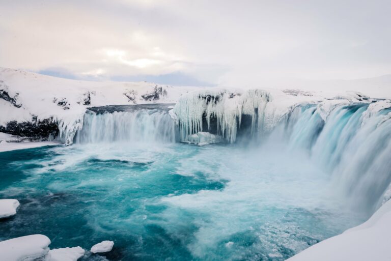 Goðafoss waterfall framed by ice in winter