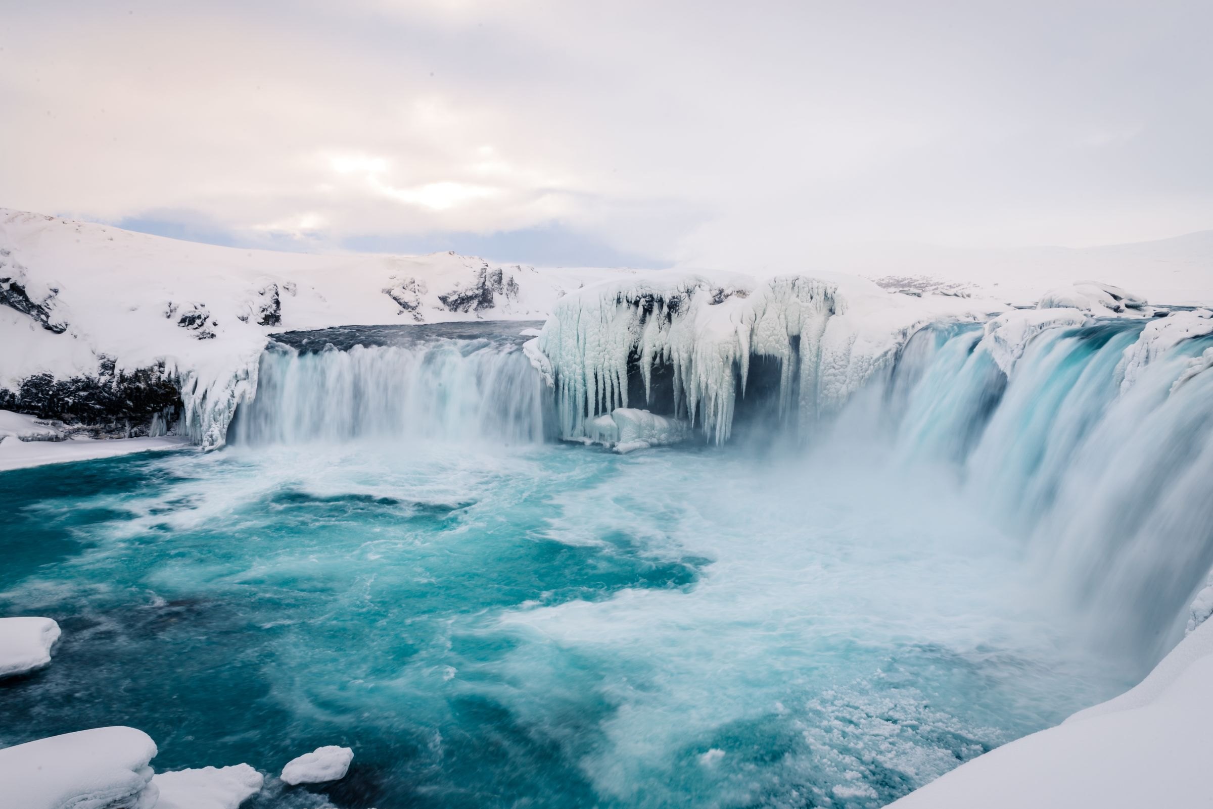 Goðafoss waterfall framed by ice in winter