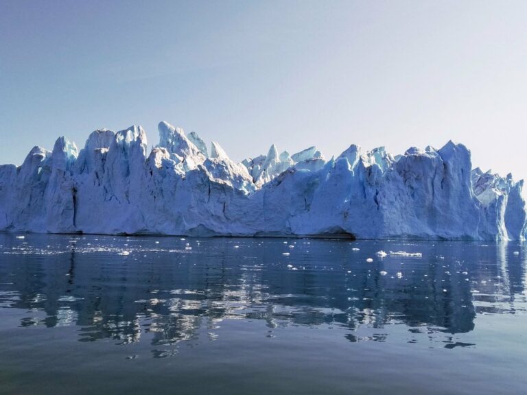 A massive iceberg reflected in calm Greenland waters