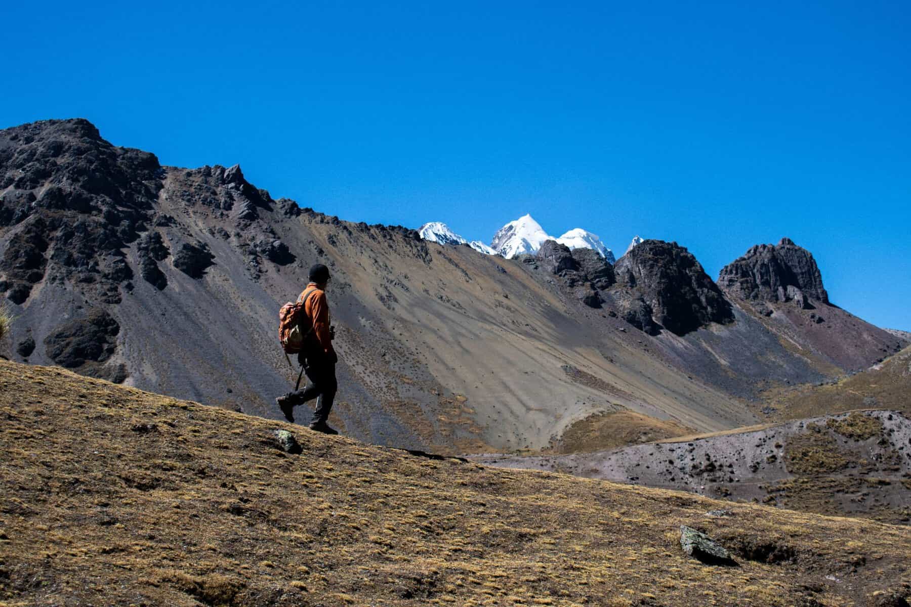 A hiker crossing a rugged Andean landscape