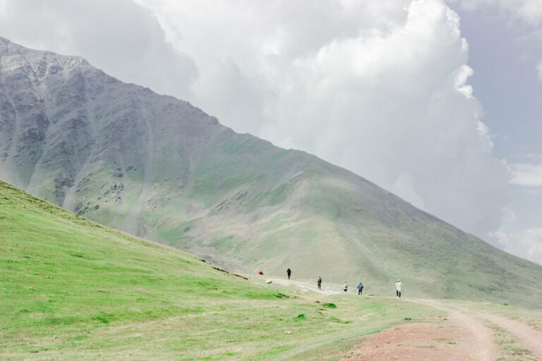 Hikers in the green mountains of Chuy Region