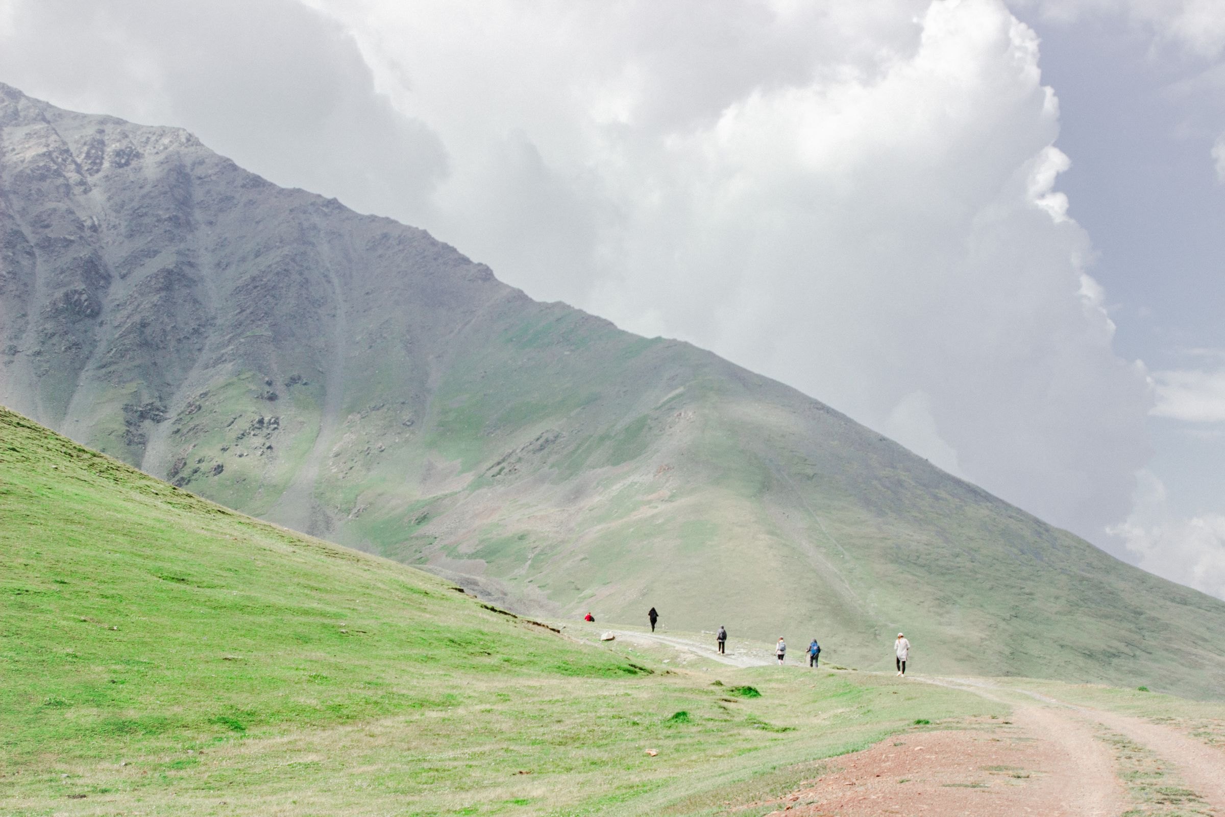 Hikers in the green mountains of Chuy Region
