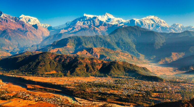 Snow-capped Himalayan peaks above green valleys