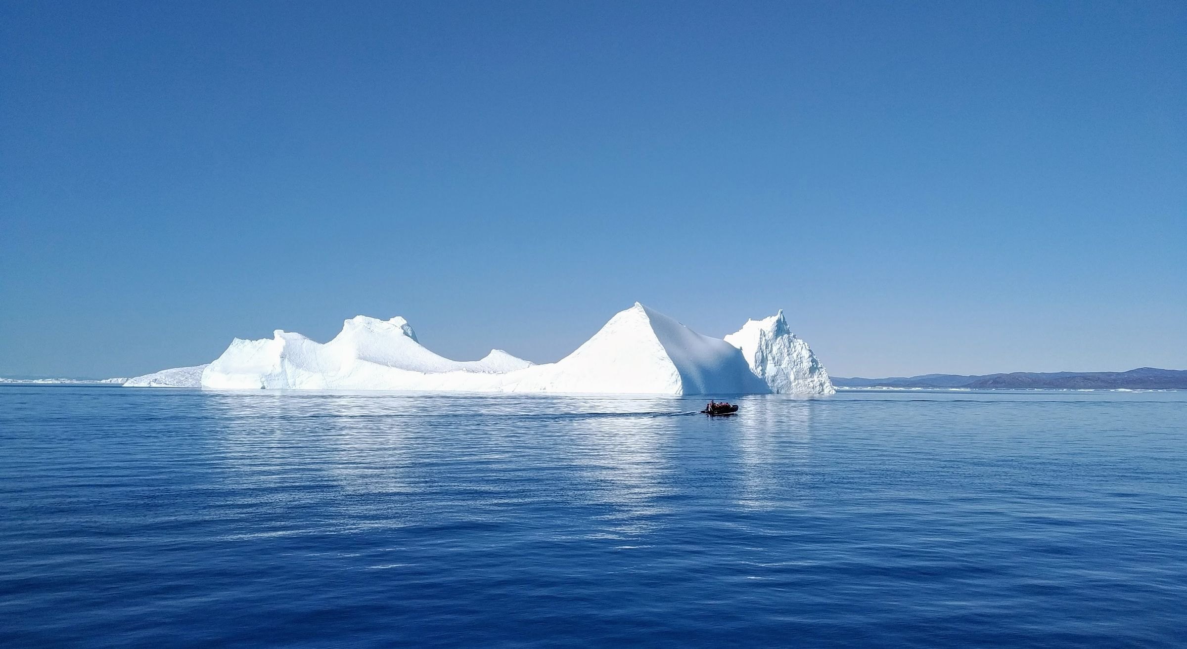 A small boat beside an iceberg at Ilulissat