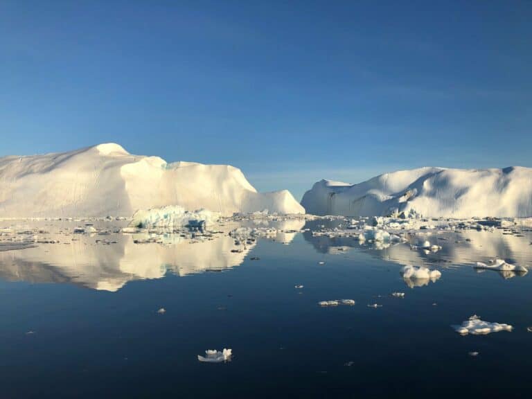 Icebergs reflected in calm water at Ilulissat, Greenland