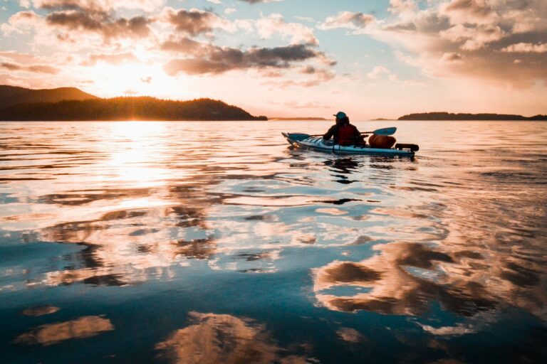 A kayaker paddling at sunset off British Columbia