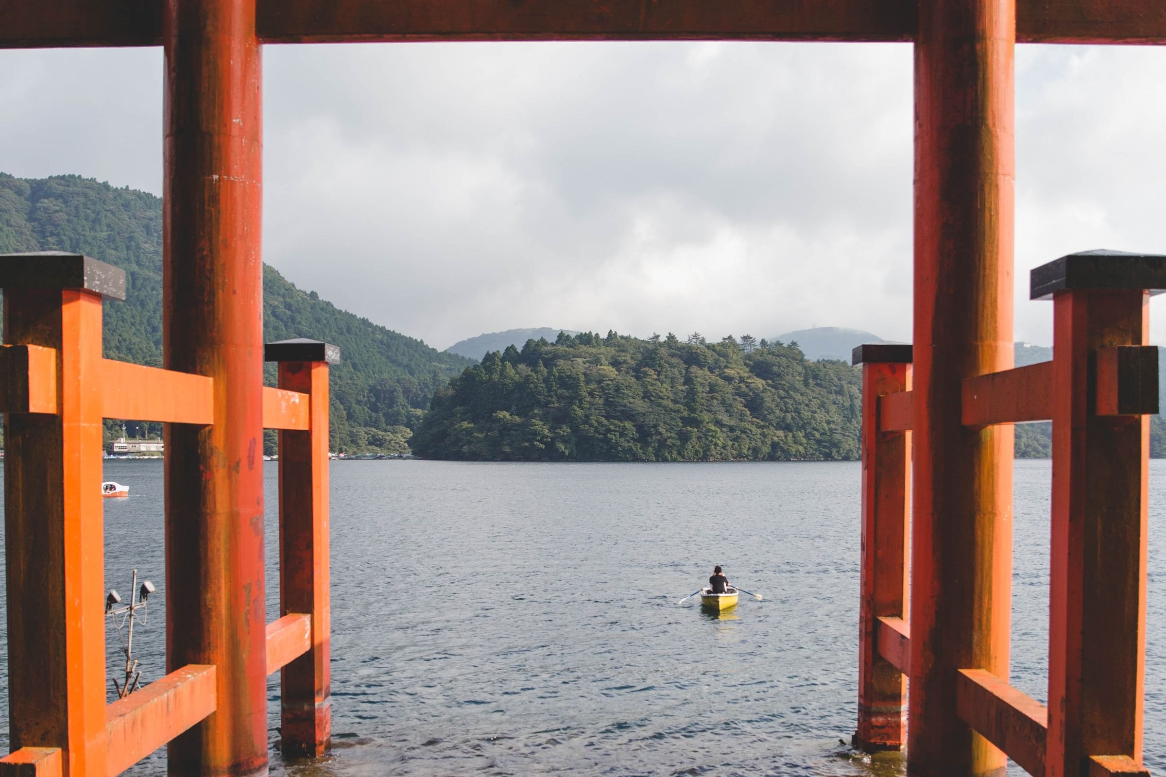 A kayaker on a lake beneath a torii gate