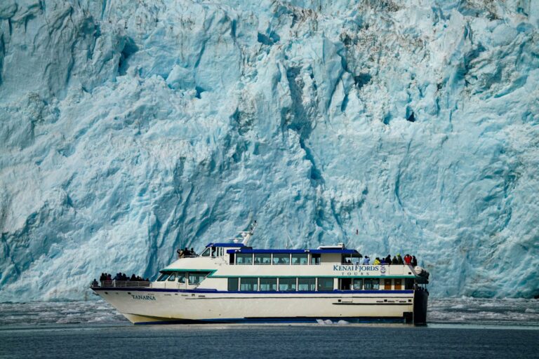 A boat below a glacier in Kenai Fjords