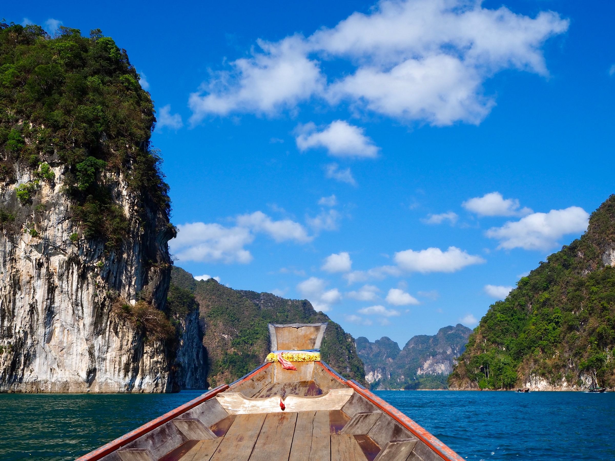 A longtail boat among the cliffs of Khao Sok Lake