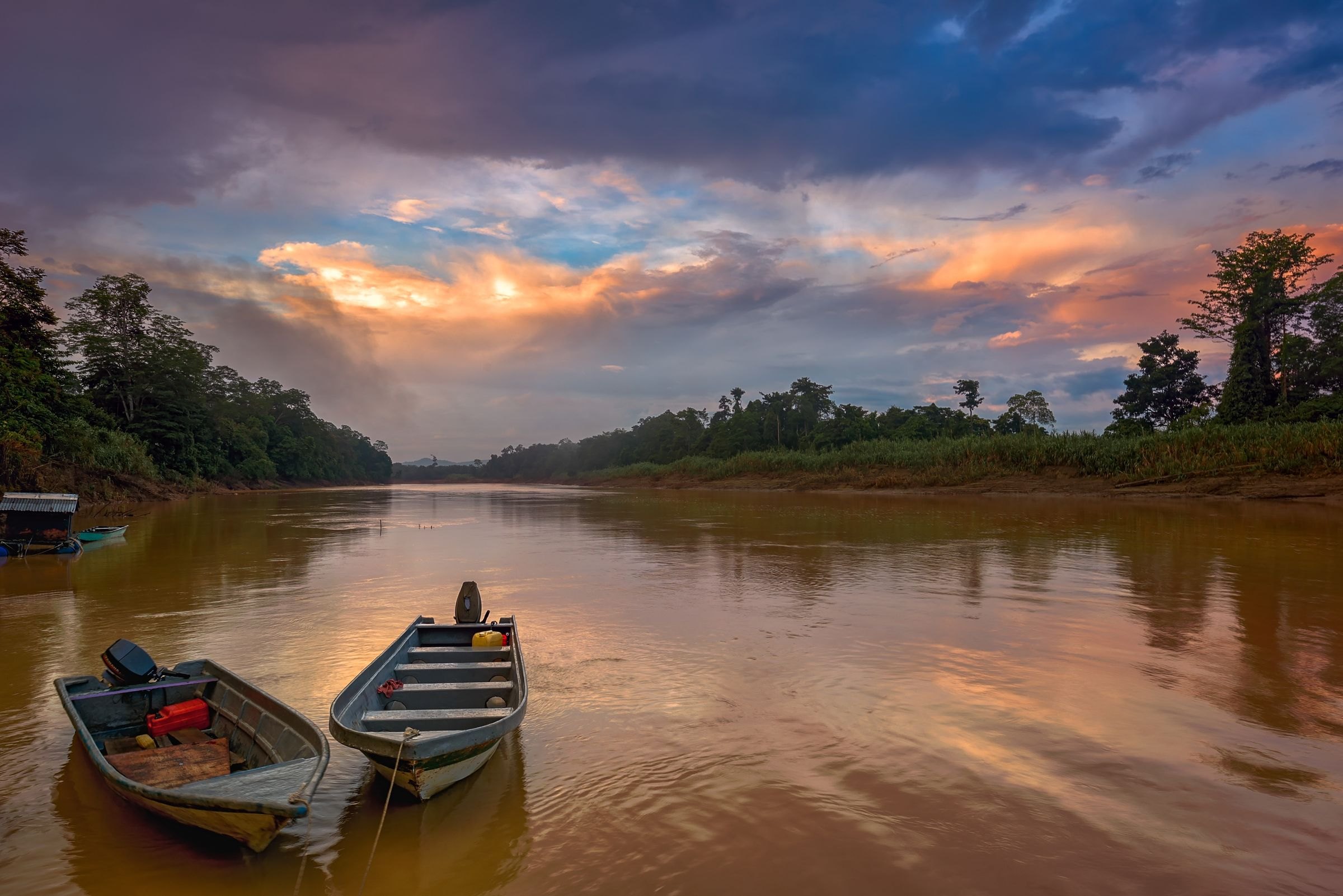Boats on a jungle river at sunset