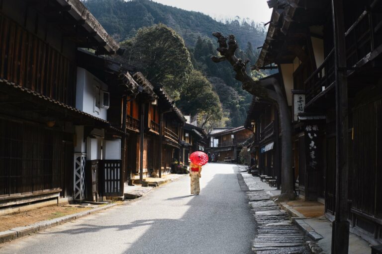 A woman with a red umbrella in a Kiso Valley post town
