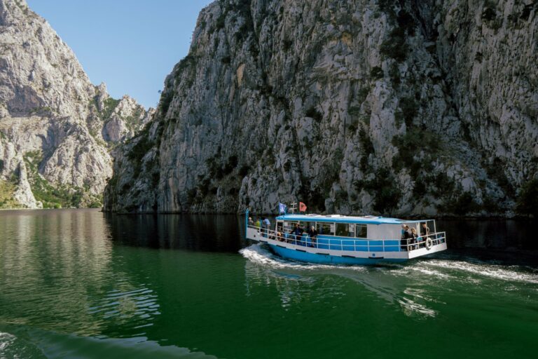 A ferry on Koman Lake between steep cliffs