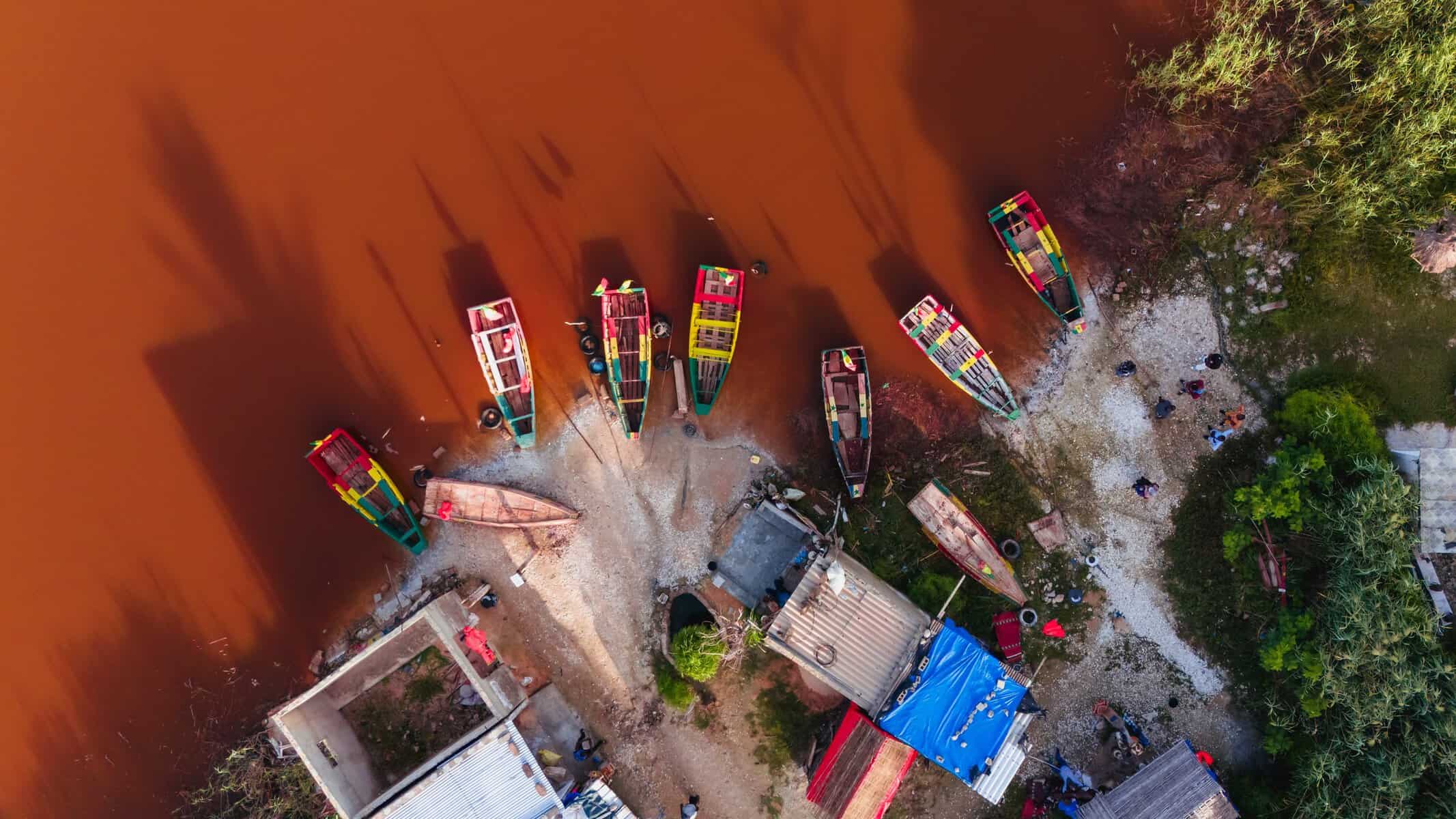 Aerial view of fishing pirogues at the edge of the Pink Lake (Lac Rose), Senegal