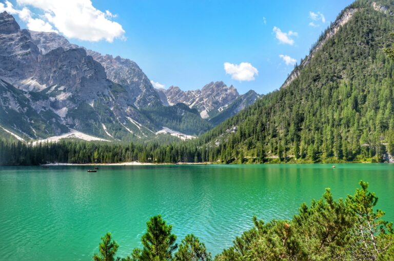 The emerald water of Lago di Braies below forested peaks