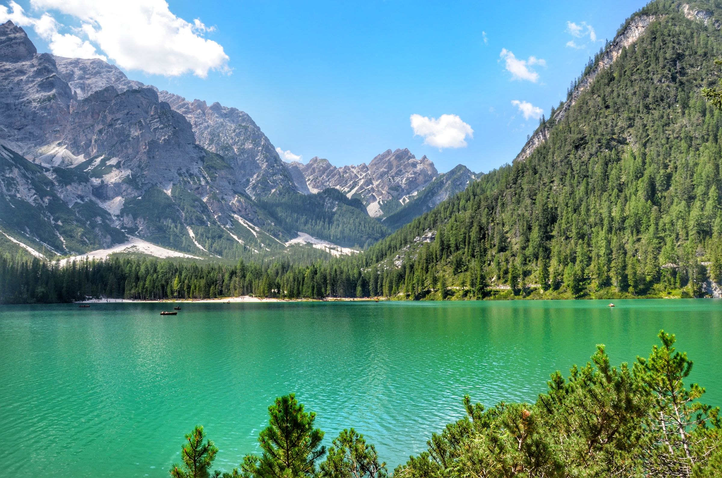 The emerald water of Lago di Braies below forested peaks