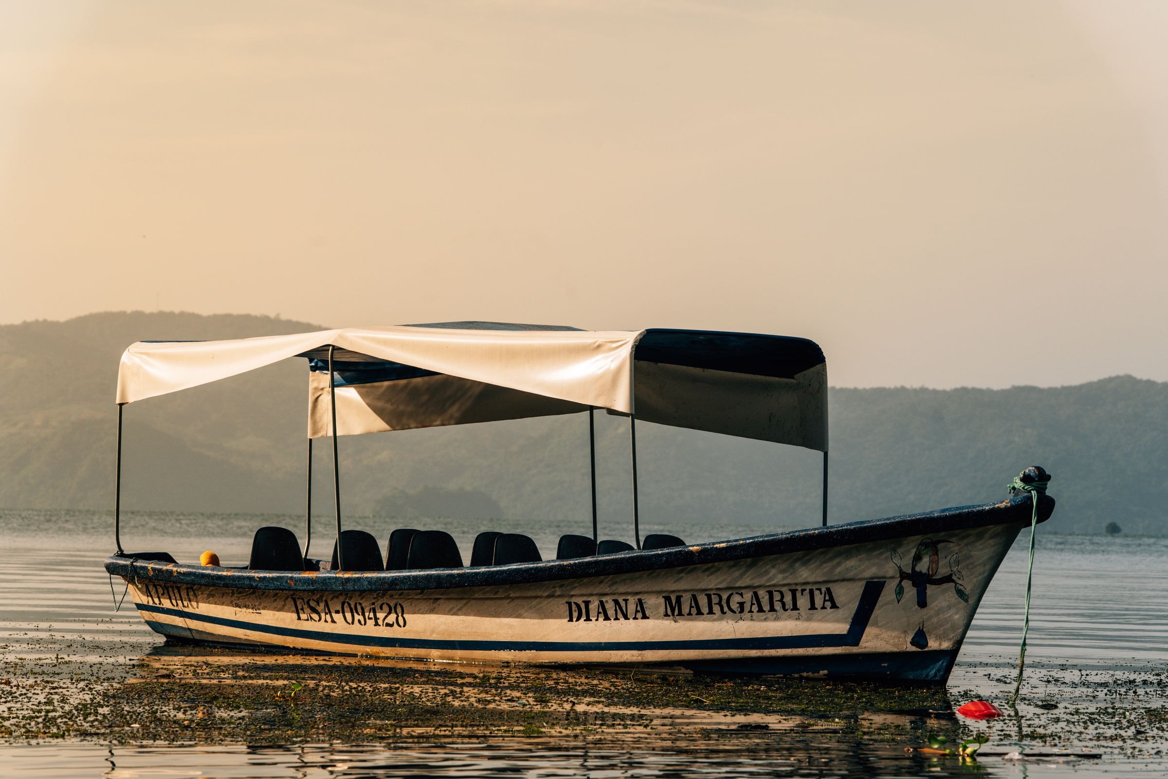 A boat on Lake Coatepeque at dawn