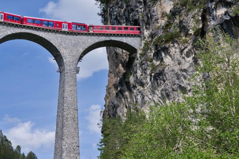 A red train crossing the Landwasser Viaduct in Switzerland
