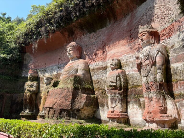 Buddha statues carved into the red cliffs at Leshan