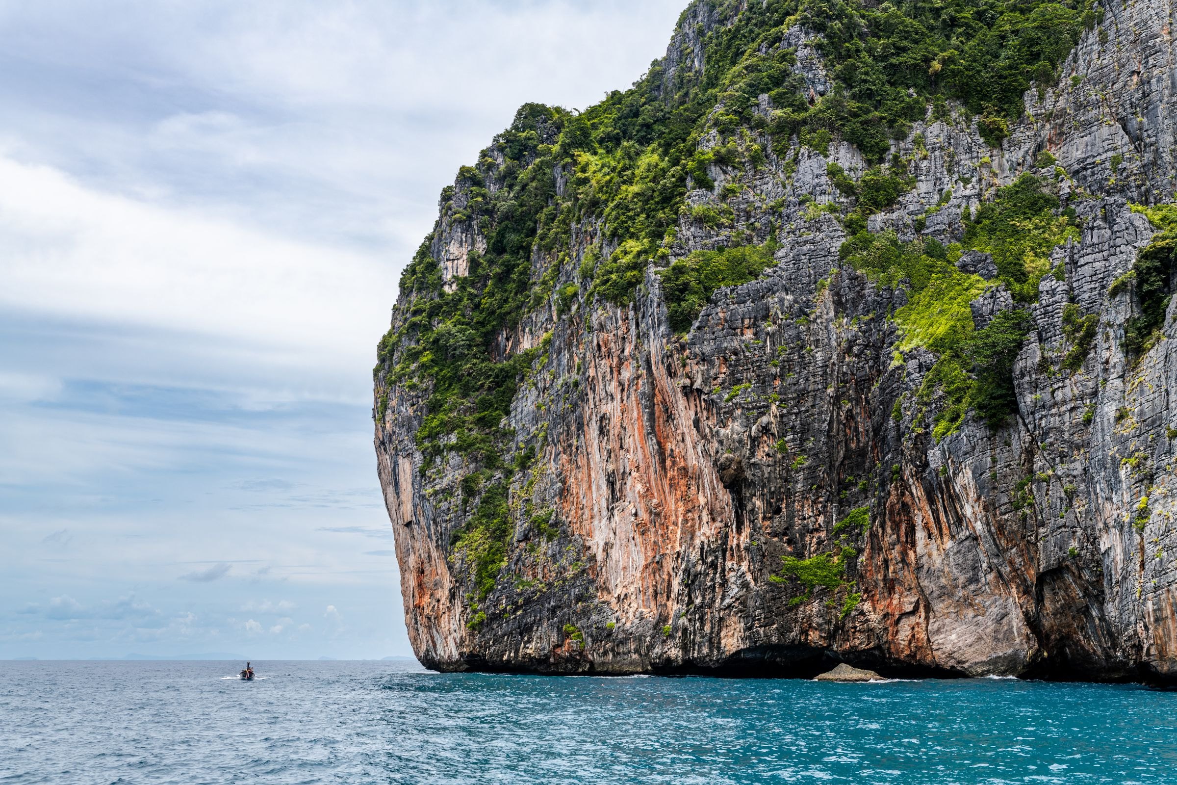 A limestone cliff rising from turquoise water