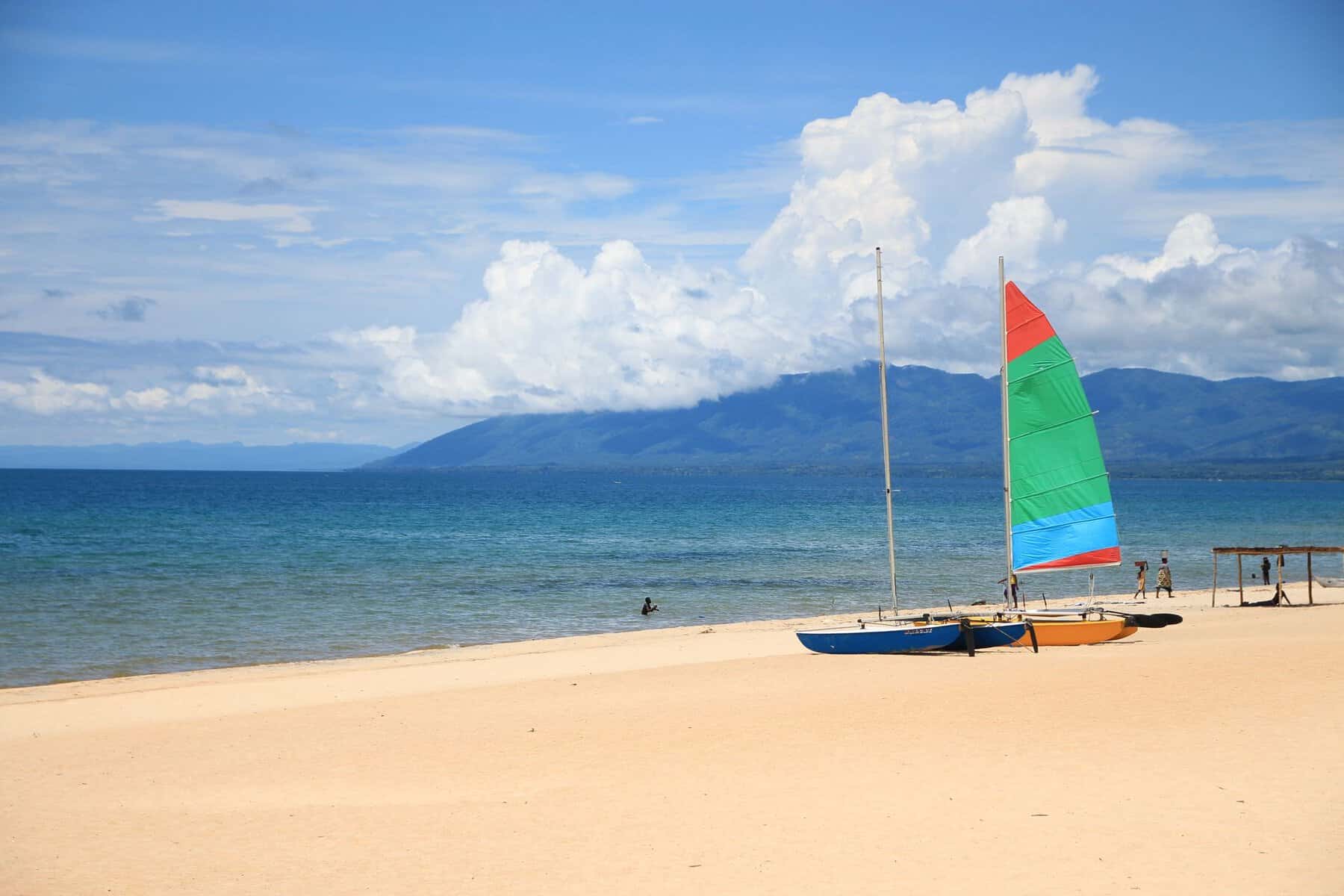 Sailboats on a Lake Malawi beach with mountains behind