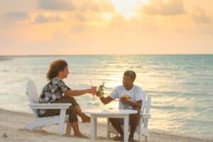 Couple sharing sunset drinks on the beach at a Maldives resort